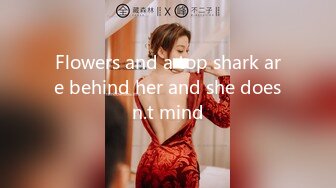 Flowers and a top shark are behind her and she doesn.t mind